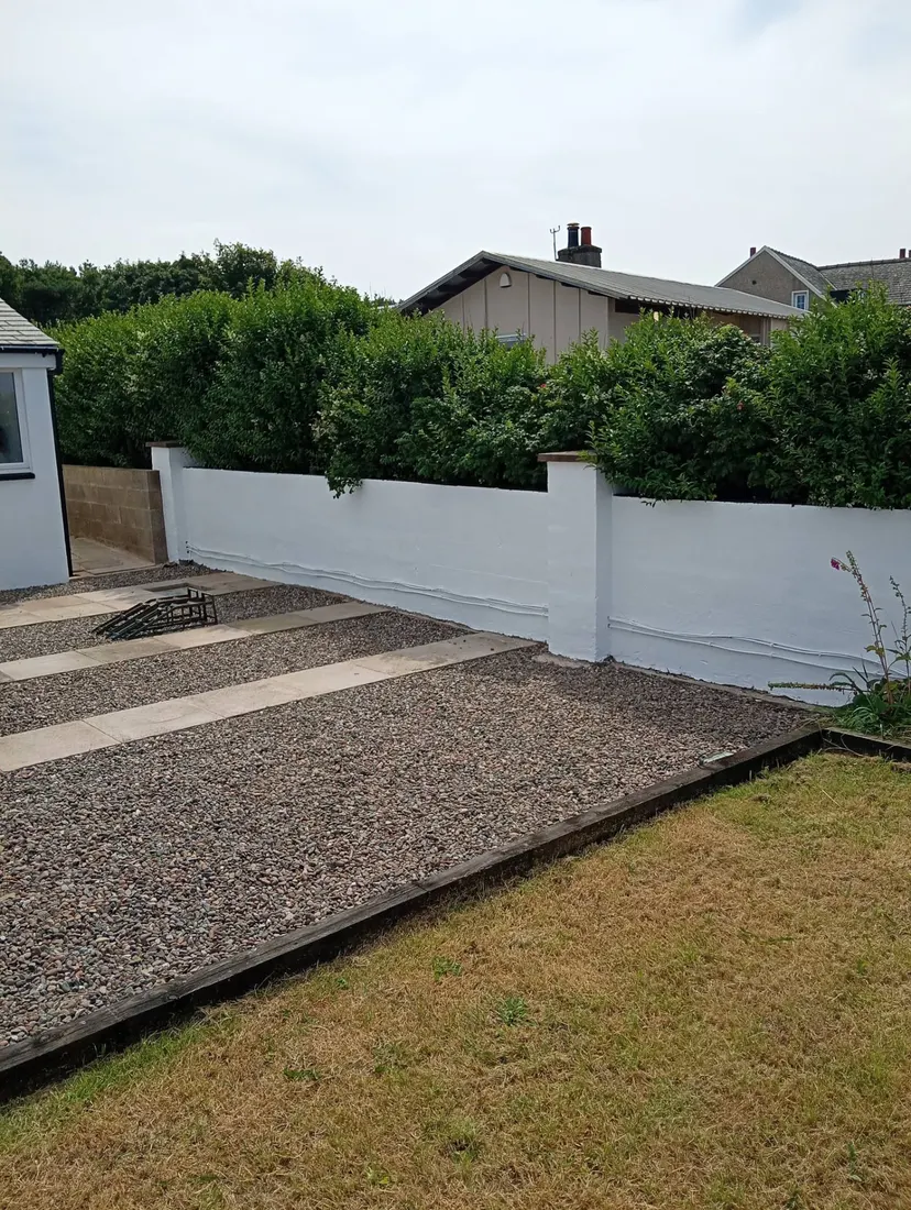 Freshly painted white exterior garden boundary wall